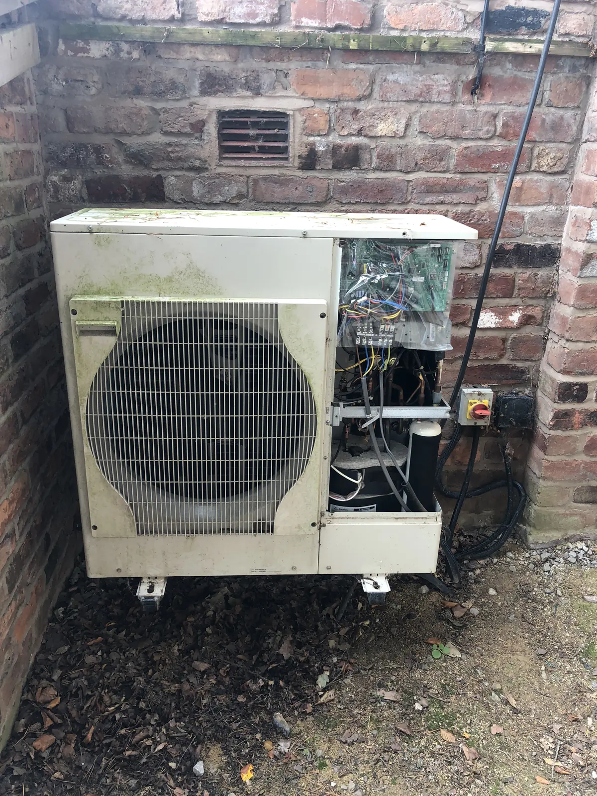 Air source heat pump outdoor unit with the cover off during a service visit